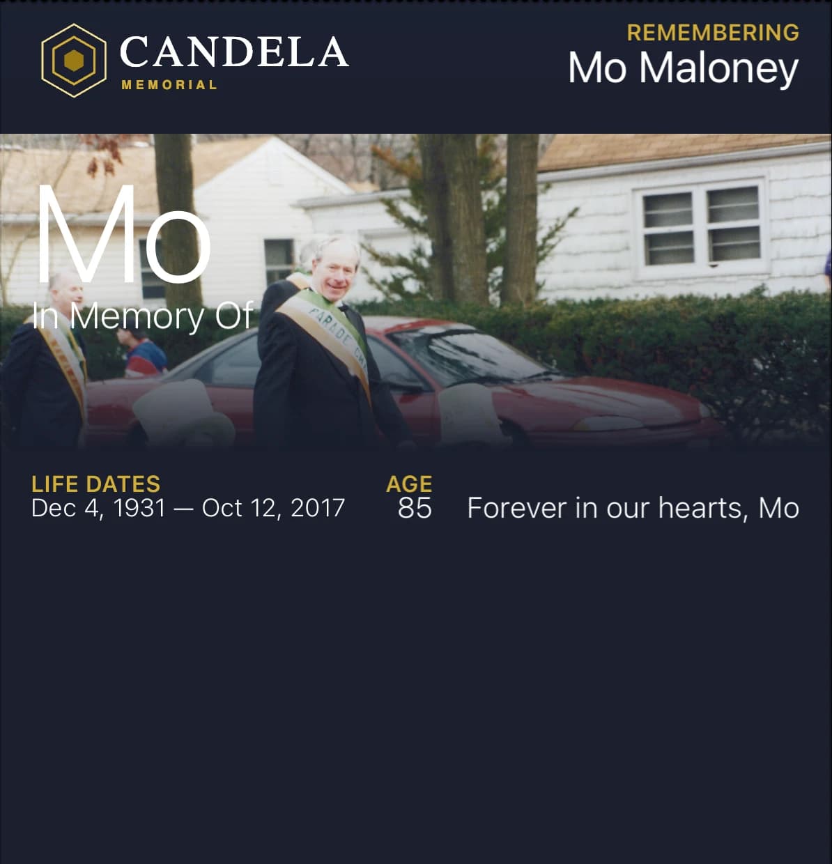 Mo Maloney's Candela Card in Apple Wallet. His photograph at a parade, his name, the dates Dec 4, 1931 to Oct 12, 2017, age 85, and the line: Forever in our hearts, Mo.